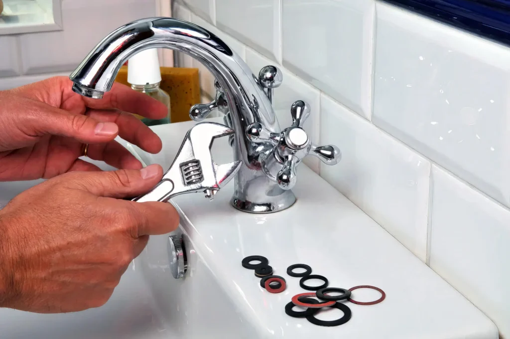 Plumber performing maintenance on a bathroom faucet in Mableton